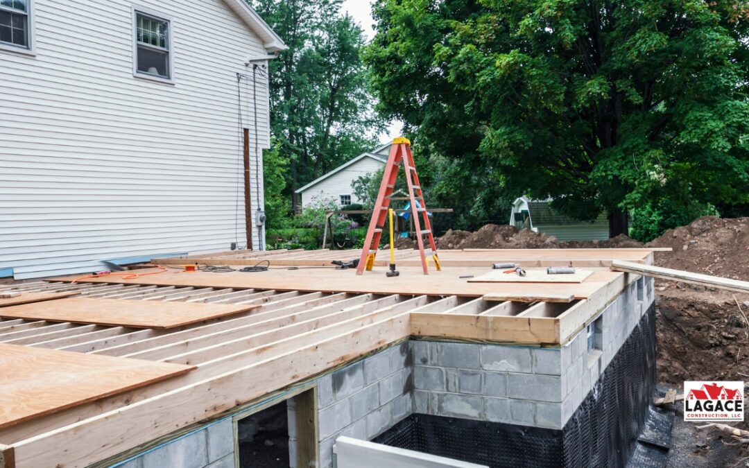 In-law suite addition under construction in Connecticut, showing foundation, framing, and plywood installation by Lagace Construction.